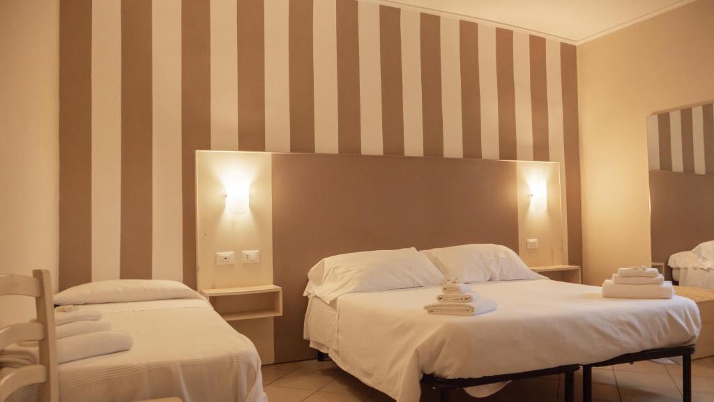 a hotel room with two beds with towels on them at Hotel La Smorfia in Castiglioncello