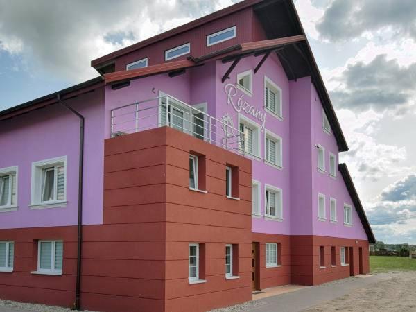 a pink and purple building with aventh floor at Noclegi"DOM RÓŻANY" Myszyniec in Myszyniec