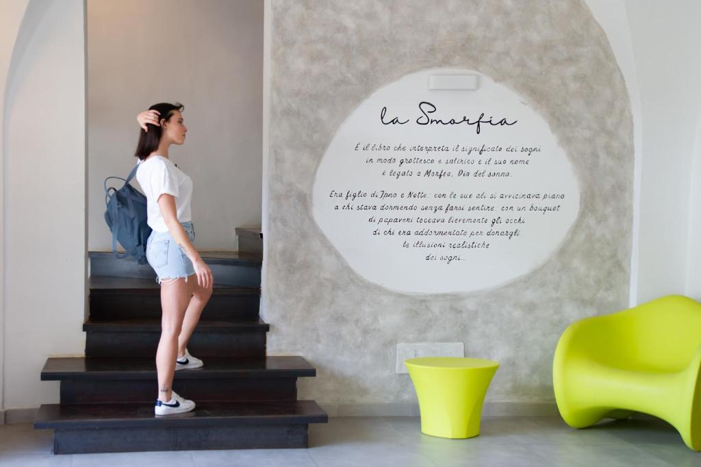 a woman standing on the stairs in a room at Hotel La Smorfia in Castiglioncello