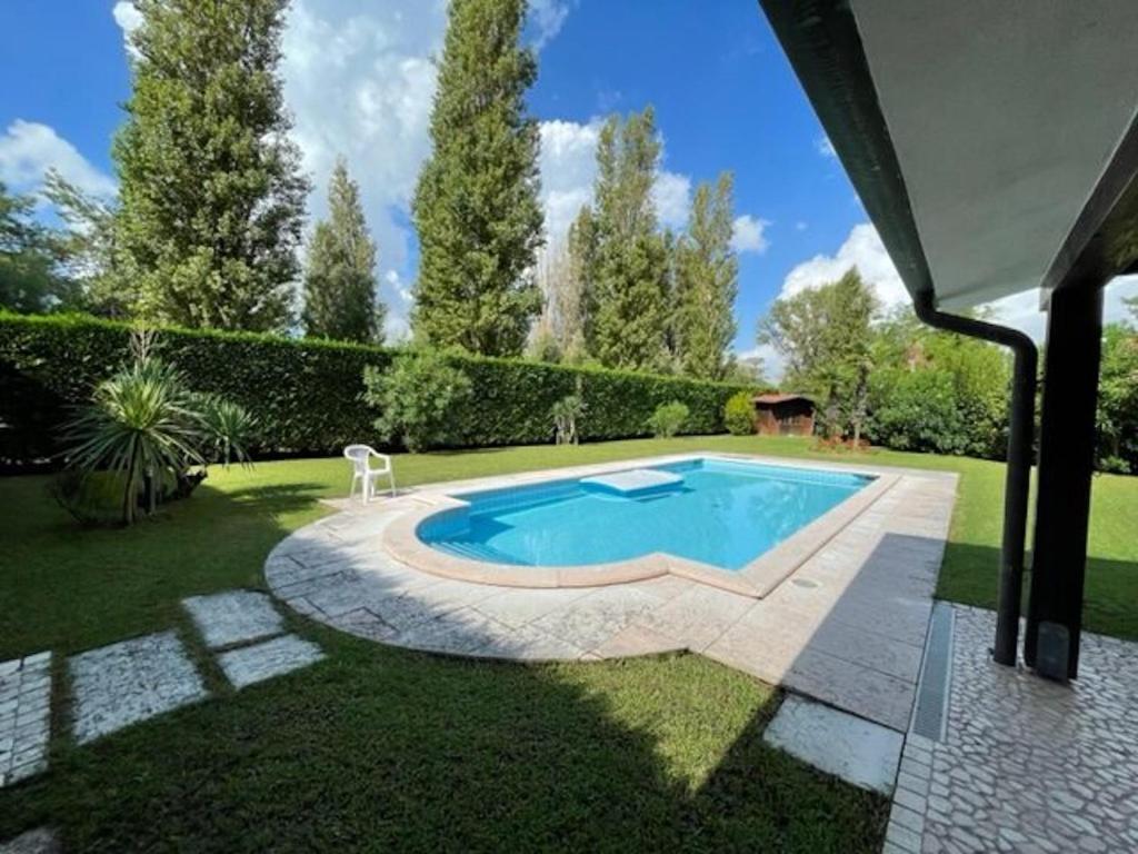 een zwembad in een tuin met een patio bij Fantastic villa with pool surrounded by nature in Palazzo Vianello