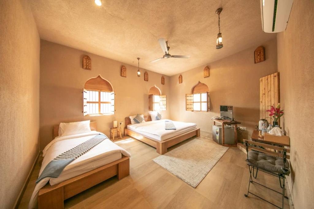 a bedroom with two beds in a room at Alaqur View Inn نزل واجهة العقر in Nizwa
