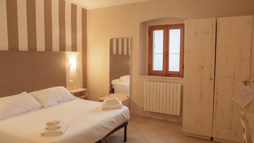 a bedroom with a bed with two towels on it at Hotel La Smorfia in Castiglioncello