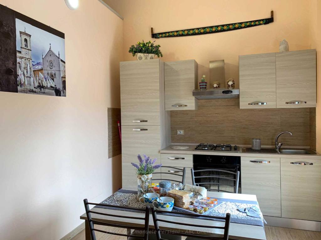 een keuken met een tafel met stoelen en een wastafel bij La Cascina delle Viole in Norcia