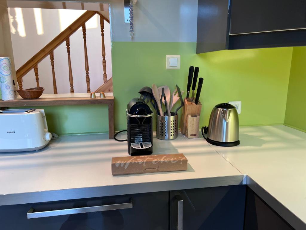 a kitchen counter with a coffee maker and utensils at Maison Climatisée 04 chambres Paris Disney CDG in Gagny