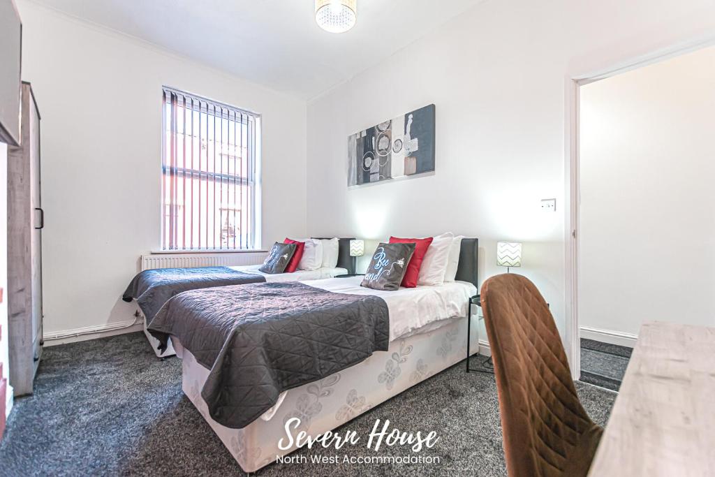 a bedroom with two beds and a table at Severn Street House Serviced Accommodation in Leigh