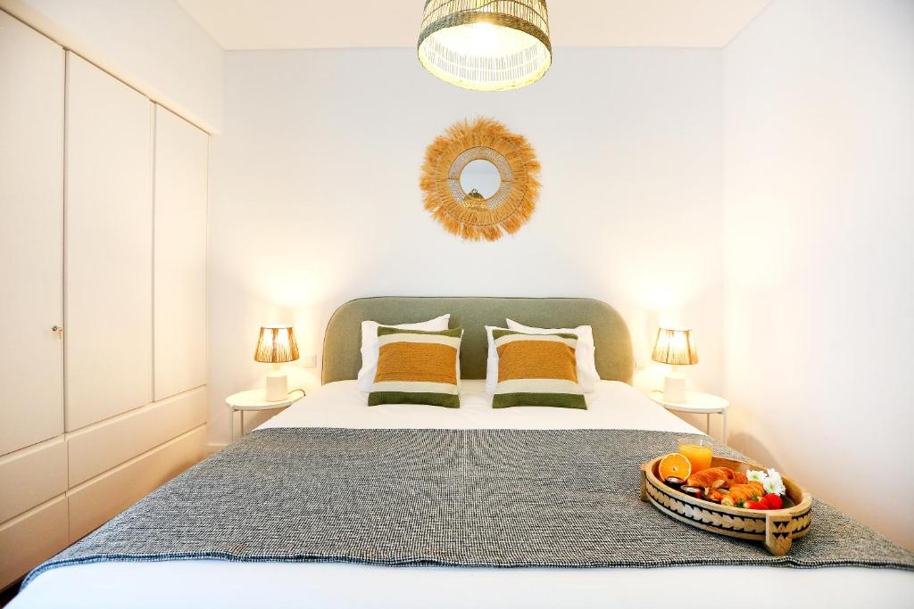 a bedroom with a bed with a bowl of fruit on it at Coast Guard Apartment in Faro