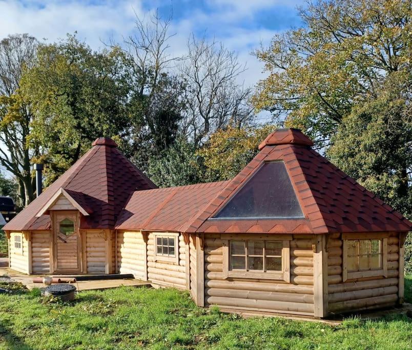 a log cabin with a copper roof at Antler Lodge in Rushton Spencer