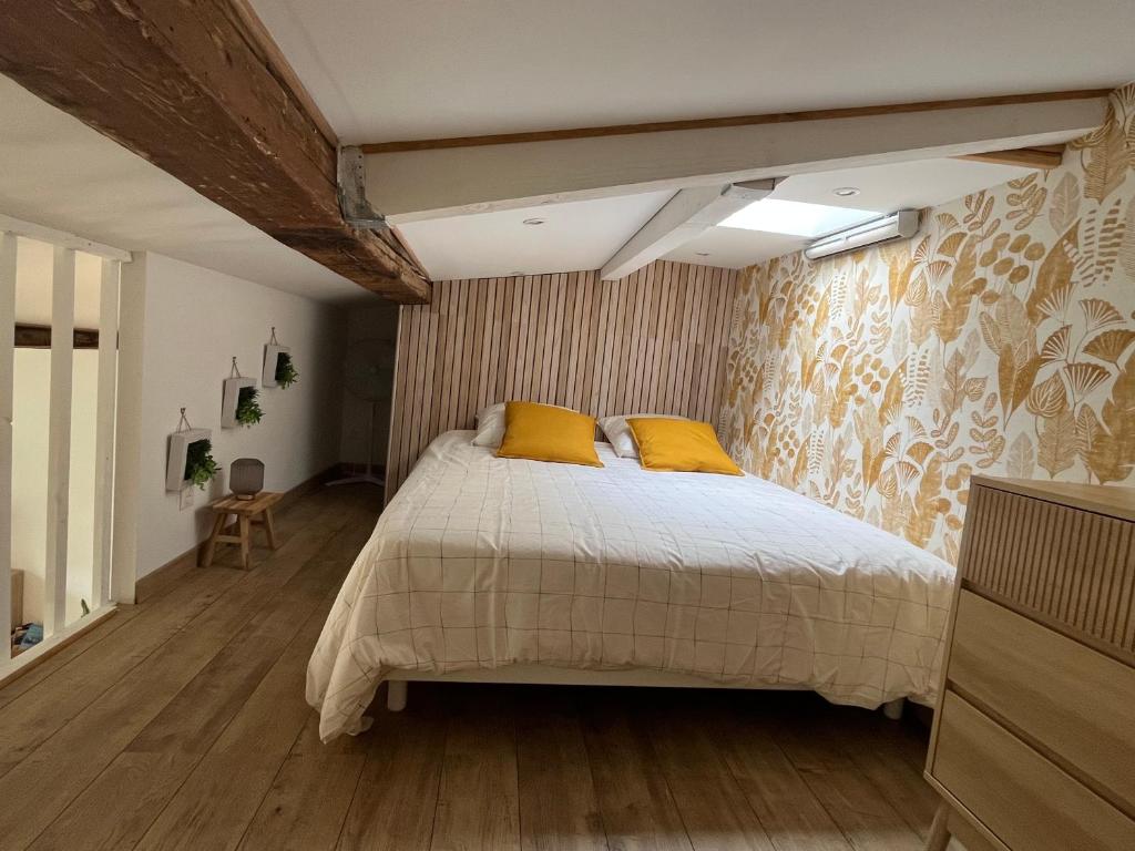 a bedroom with a large bed with yellow pillows at Vieux port LA CIOTAT 1 in La Ciotat