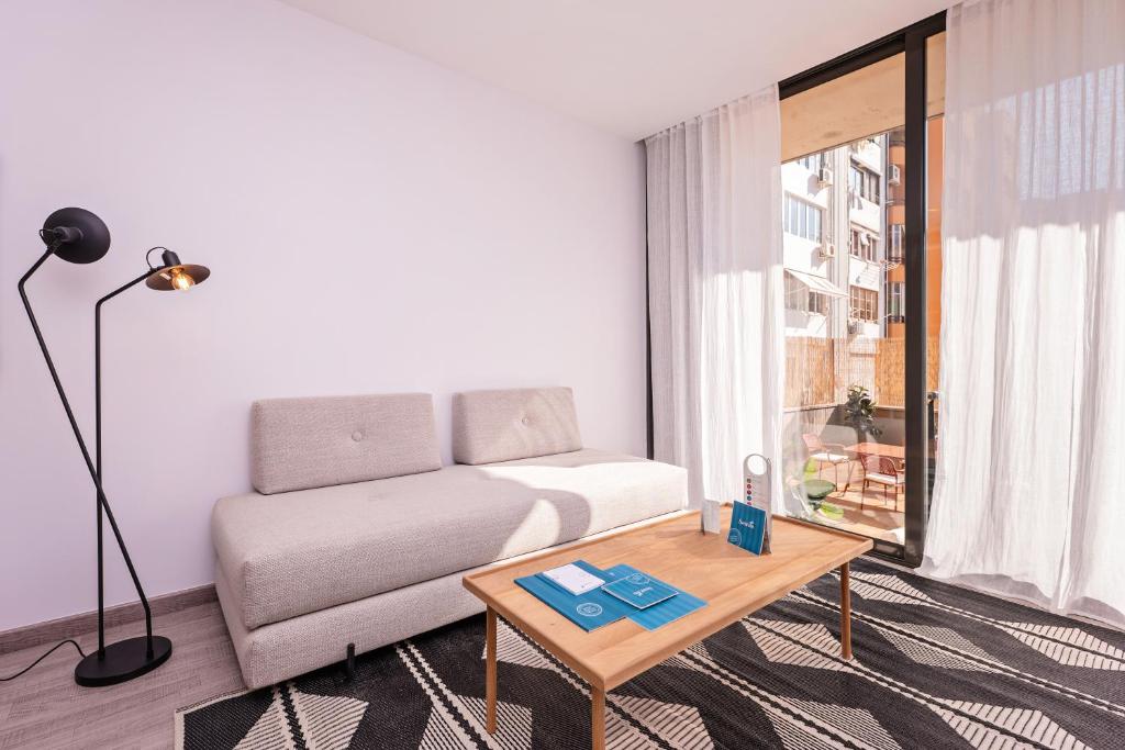 a living room with a couch and a coffee table at Sweet Inn - Carrer Fira in Barcelona
