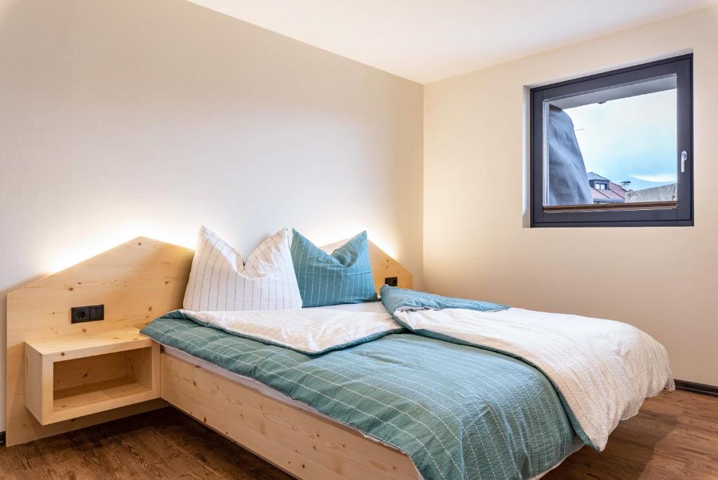ein Schlafzimmer mit einem Holzbett und einem Fenster in der Unterkunft Villa Lara Fichte in Kastelruth