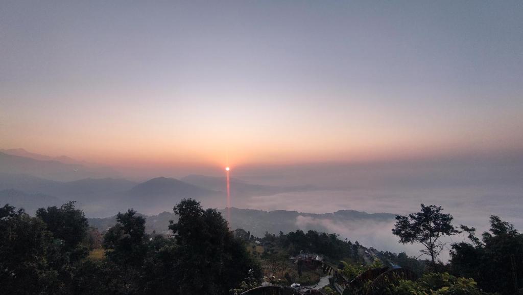 a view of the sun setting over the mountains at Sarangkot Hotel New Galaxy in Pokhara