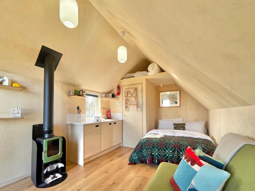 a bedroom with a wood stove in a attic at St Bede Beach Hut in Alnmouth