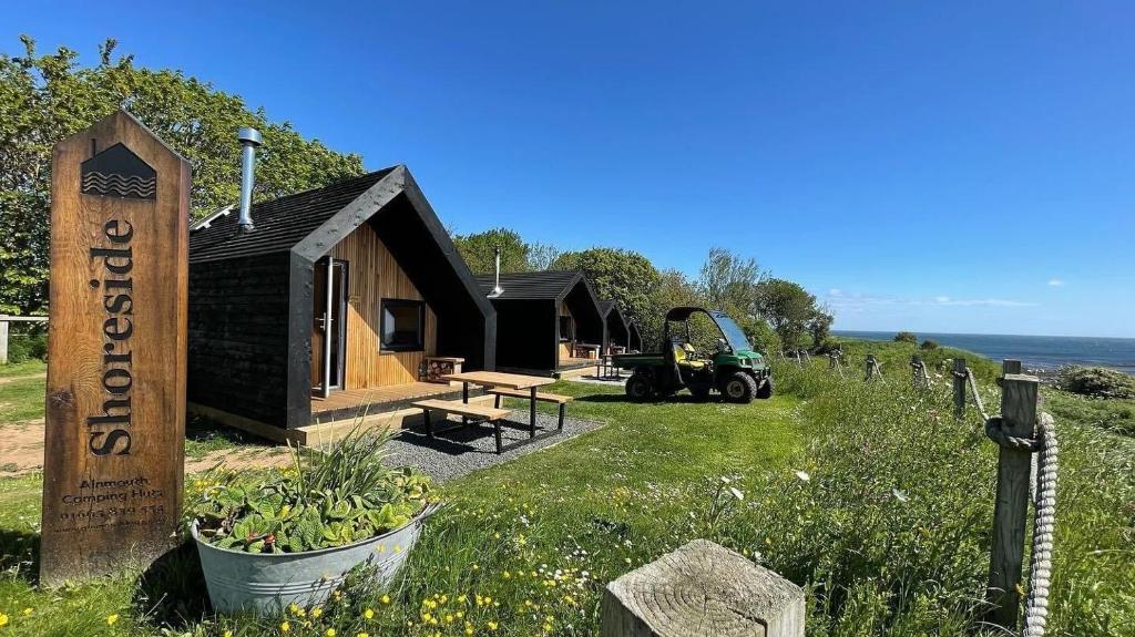 een kleine cabine met een trekker ervoor bij St Oswald Beach Hut Alnmouth in Alnmouth
