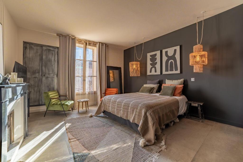 a bedroom with a bed and a chair in it at La Maison de Lyna in Aigues-Mortes