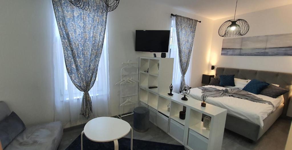 una camera con letto, TV e tende di First Studio24 a Braşov