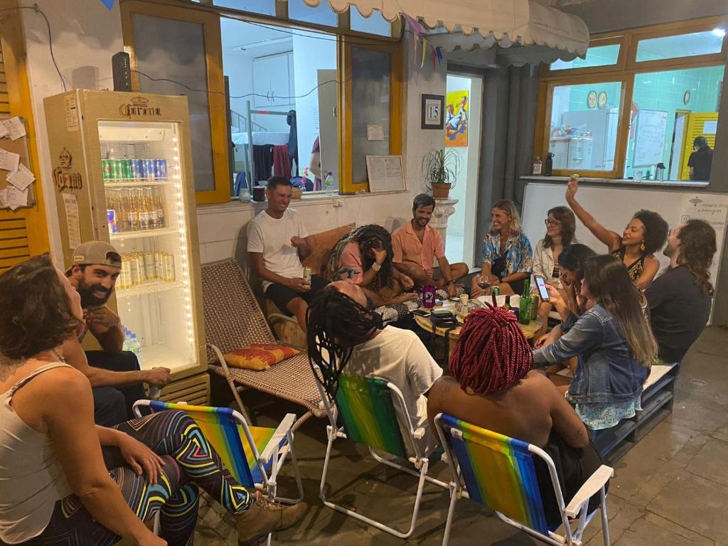 a group of people sitting around a table in a room at Nomads Hostel Multicultural & Coworking in Salvador