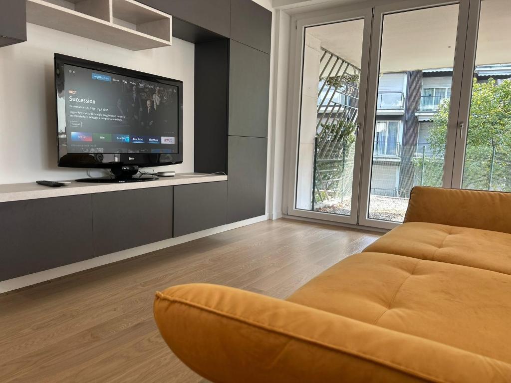 a living room with a couch and a flat screen tv at Apartment Regina Luxury Lugano in Lugano