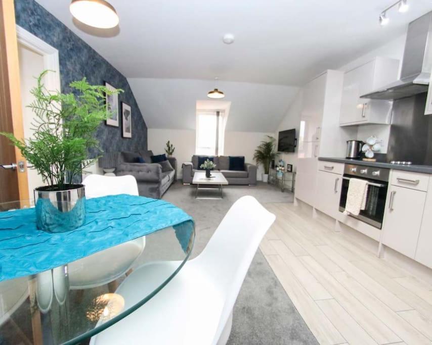 a kitchen and living room with a table and chairs at Luxe Living Guest House-Sleeps 6 -Family Friendly-Private Parking-Wifi-City-Beach in Swansea