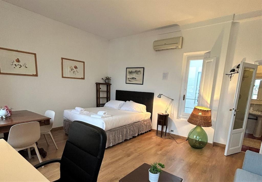 佛罗伦萨Vespucci Florence Studio的一间卧室，配有一张床、一张书桌和一张桌子