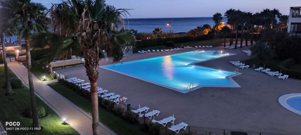 - une vue sur la piscine avec des chaises et l'océan dans l'établissement WIFI Los Cisnes 2 dormitorios Primera Linea playa Ayamonte Isla Canela, à Isla Canela