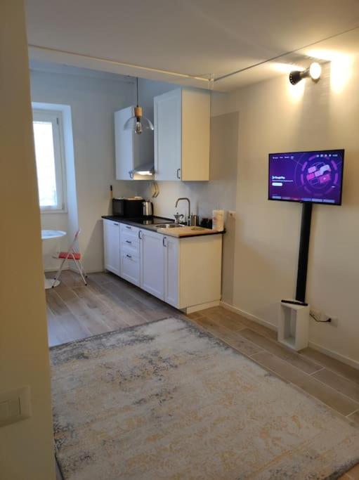 a kitchen with a tv hanging on the wall at Appartamento Galgano Prato centro in Prato