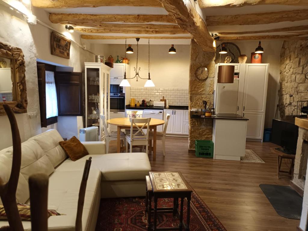 ein Wohnzimmer und eine Küche mit einem Sofa und einem Tisch in der Unterkunft Can vinyals 1979 in La Pobla de Cérvoles