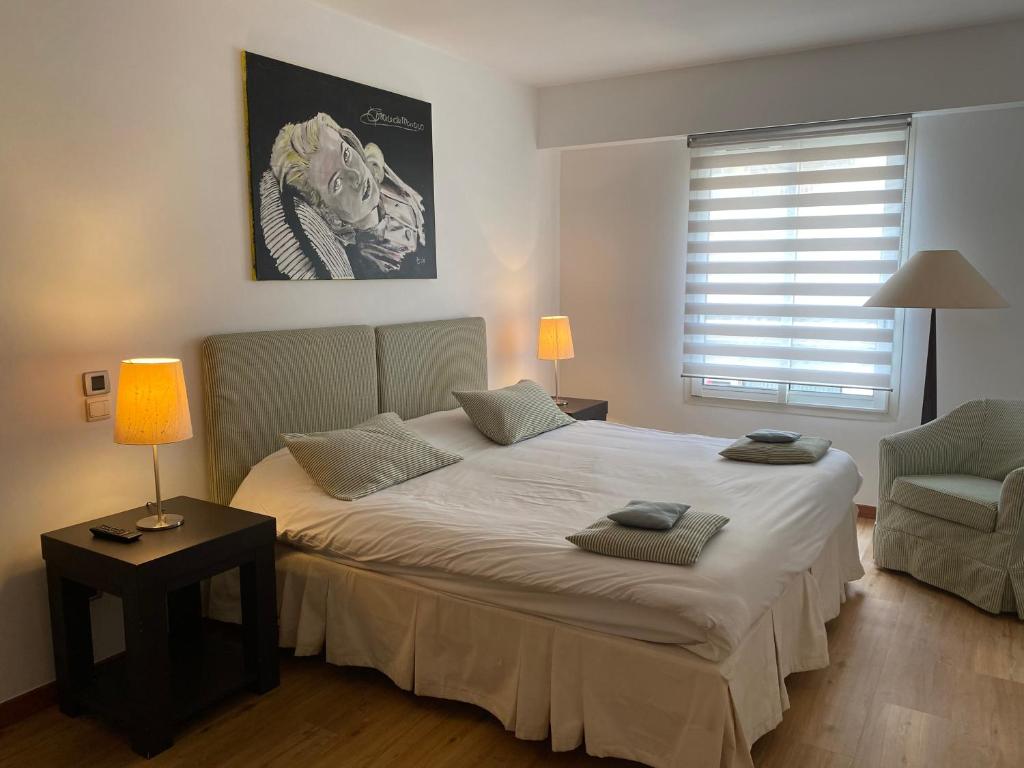 1 dormitorio con 1 cama grande y 1 silla en Arthur Properties Rue d'Antibes, en Cannes