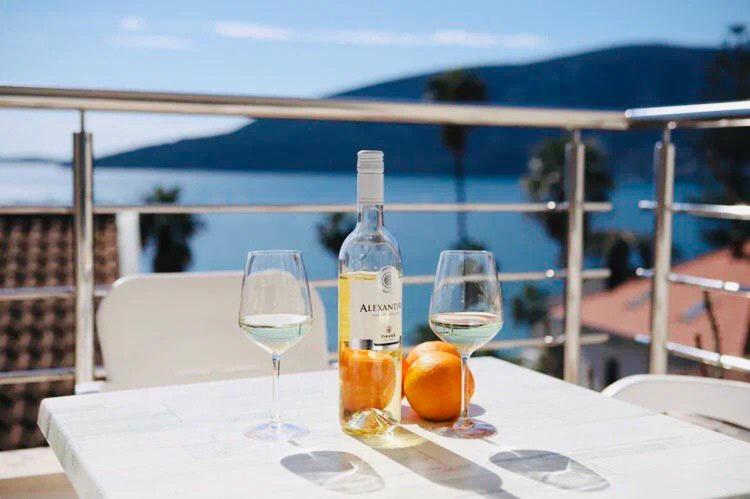 uma garrafa de vinho e dois copos numa mesa em Boka Residence 8 em Herceg Novi
