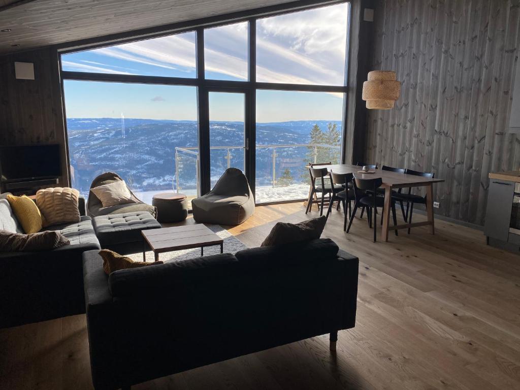 a living room with a couch and a table and a large window at Cosy apartment with ski in/out in Noresund
