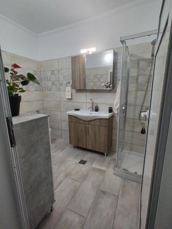 a bathroom with a sink and a shower at Vaggelitsa's House in Pythagoreio