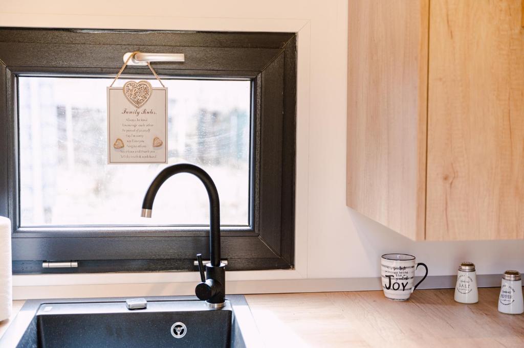 a kitchen with a black sink and a window at Moon Resort in Buşteni