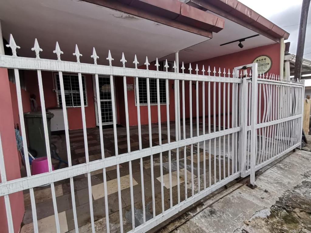 a white fence in front of a house at Natol Homestay - Kenyalang Park in Kuching