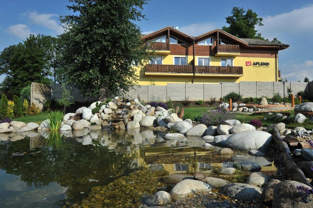 a house with a pond in front of a building at APLEND Tatry Holiday in Veľký Slavkov