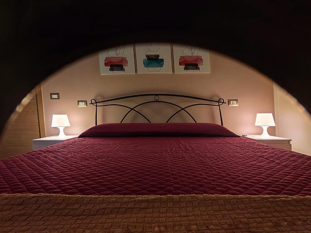テレーゼにあるb&b Telesillaのベッドルーム1室(赤い掛け布団、ランプ2つ付)