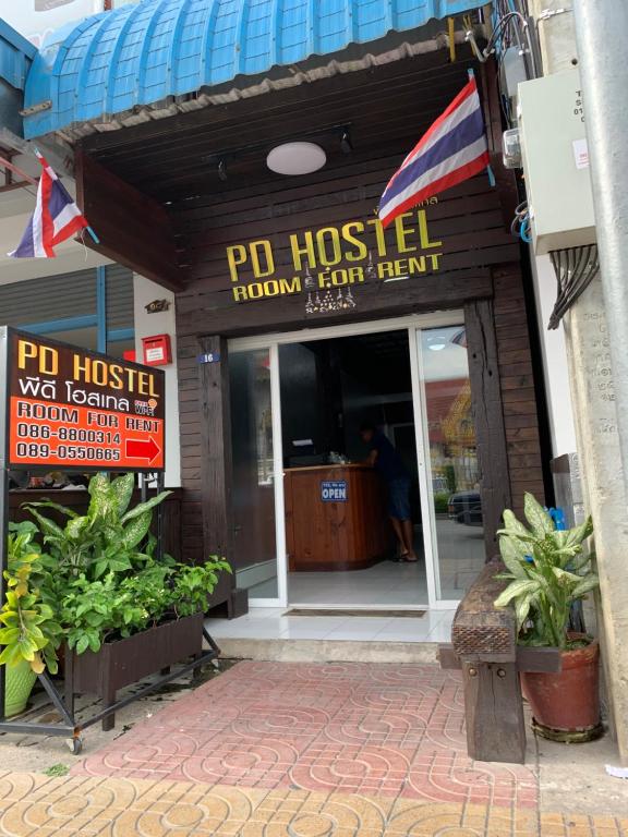 a restaurant entrance with a po hostel sign and plants at PD Hostel in Ban Don Muang