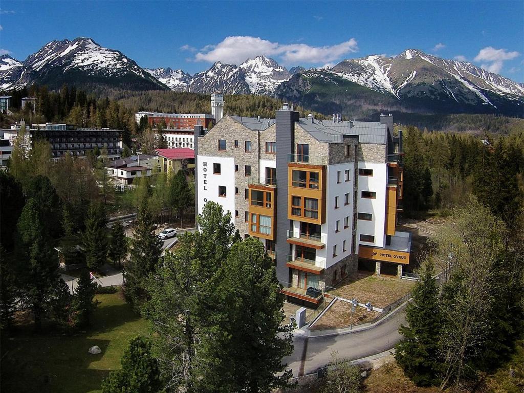 an aerial view of a building with mountains in the background at APLEND Hotel Ovruč in Štrbské Pleso