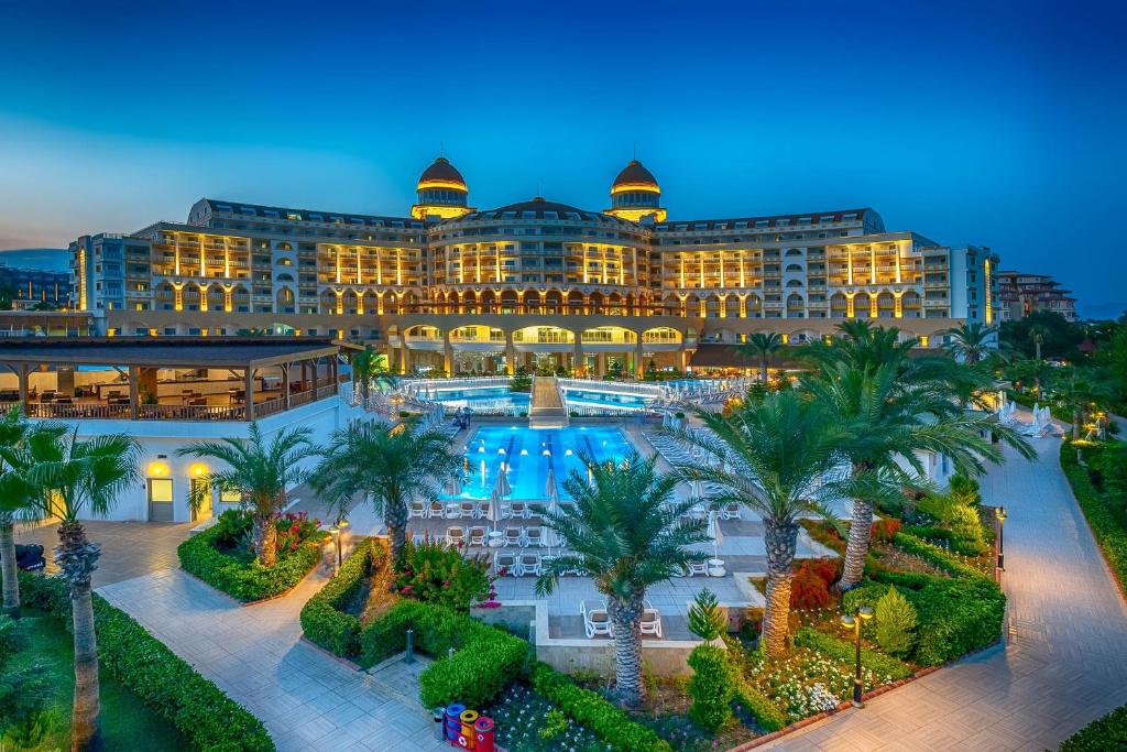 a large building with palm trees in front of it at Kirman Sidemarin Beach & Spa in Side