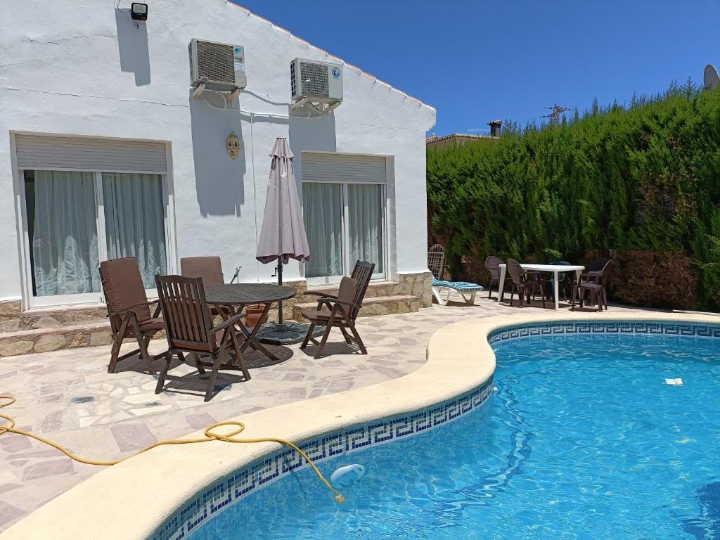 una piscina con sedie e un tavolo accanto a una casa di Casa Mar a Els Poblets