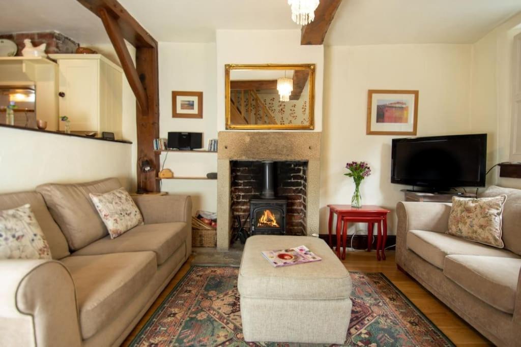 a living room with a couch and a fireplace at Characterful 2 bed cottage in excellent location in Baslow