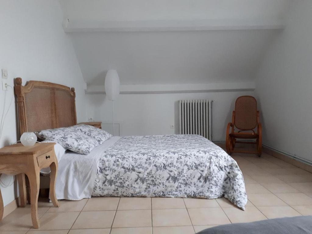 une chambre avec un lit et une chaise dans l'établissement Chez Béa, à Saint-Ouen-en-Belin