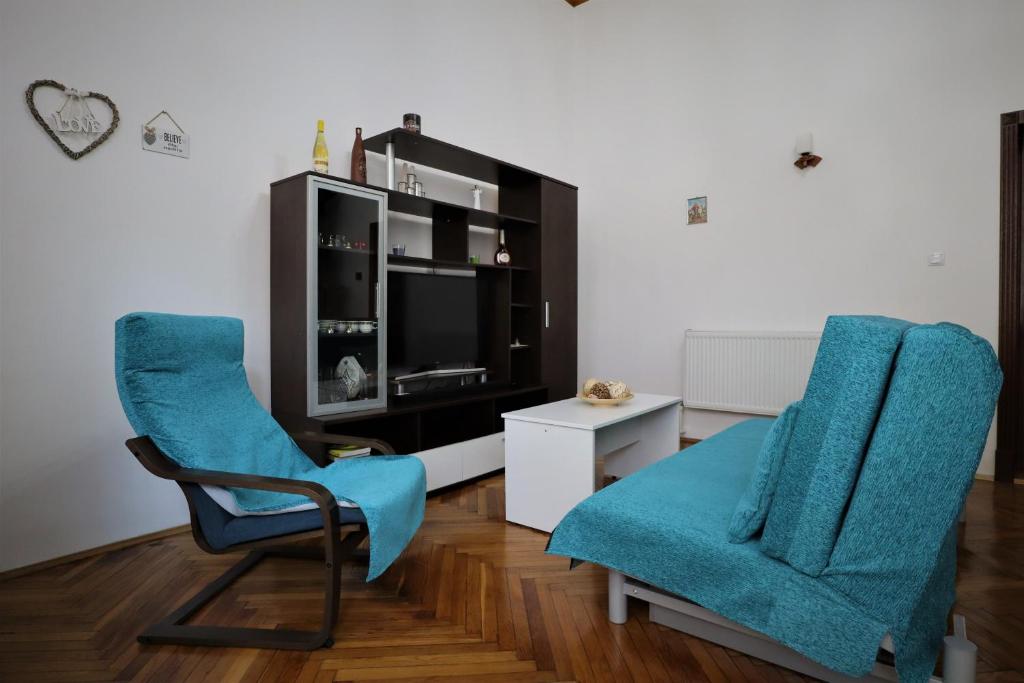 a living room with two chairs and a television at Center Haus in Bucharest