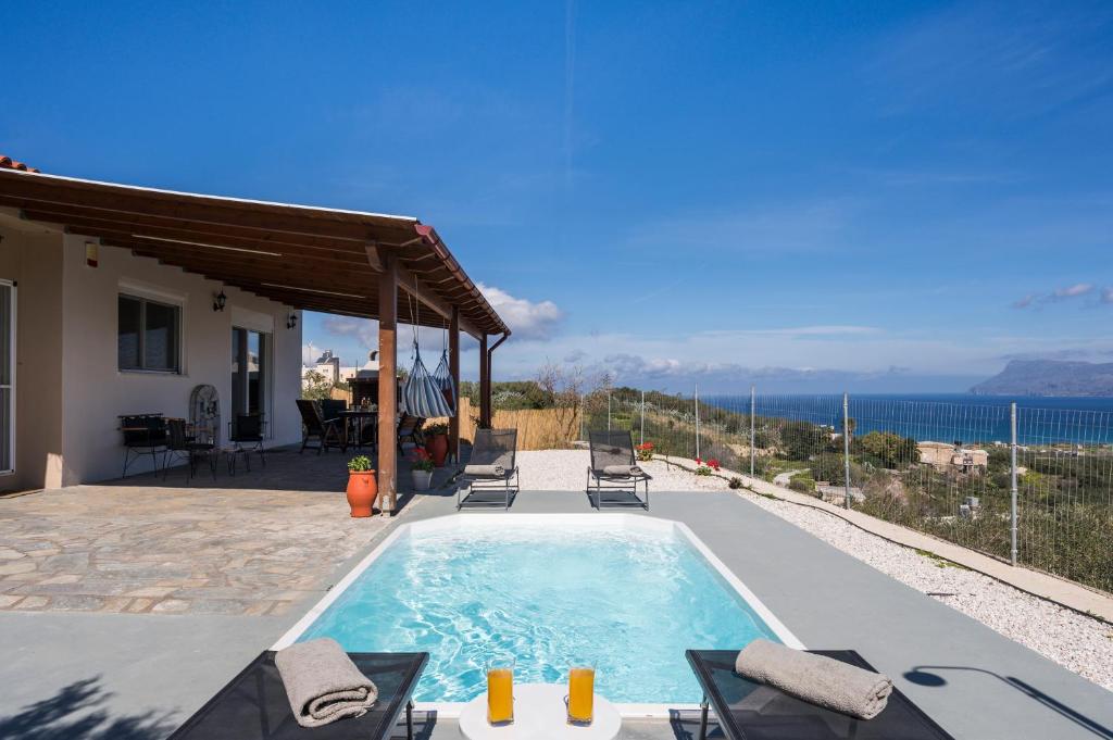 a villa with a swimming pool with a view of the ocean at Villa Cleronomia, private pool, seaview, in Kaloudhianá