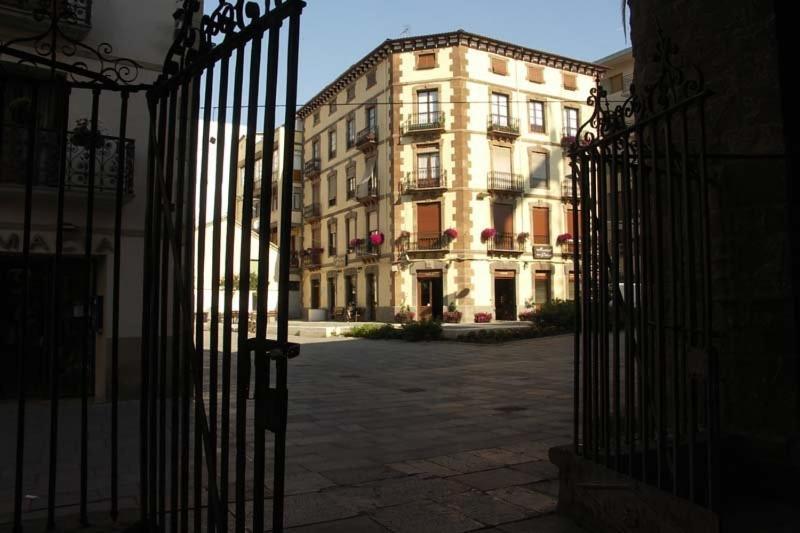 un edificio con cancello di fronte a un edificio di Hostal Paris a Jaca