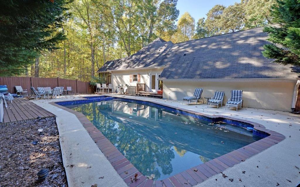 una piscina con sedie e una casa di Angel Cove Family Vacation House a Cumming