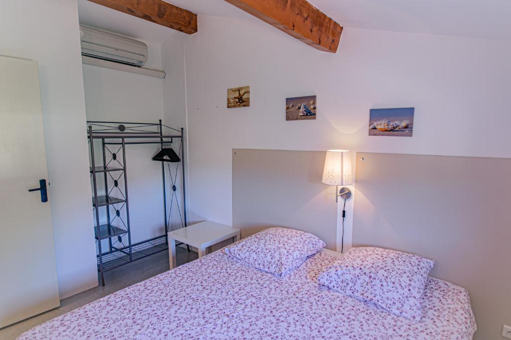 a bedroom with a bed and a table and a lamp at Domaine De Sigalous in La Crau