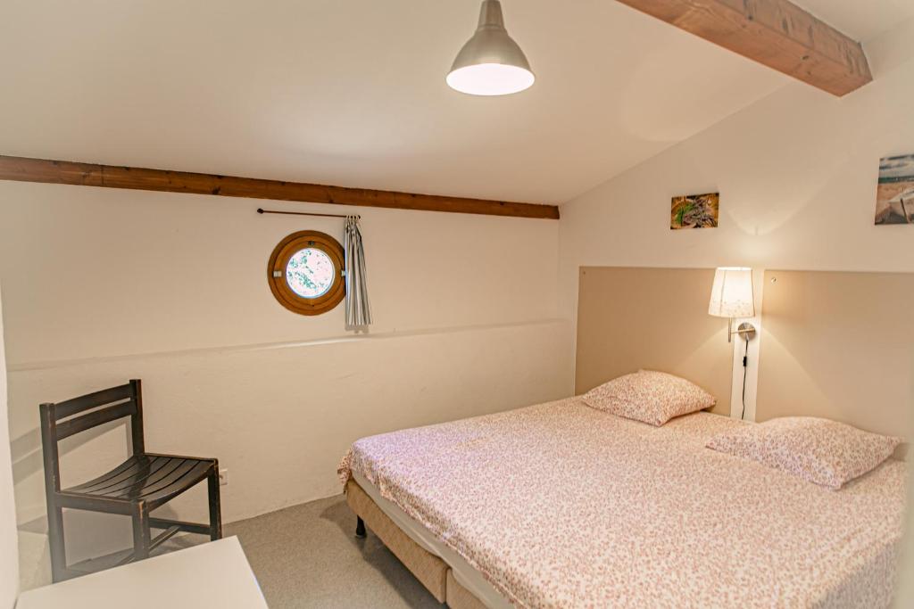 a bedroom with a bed and a chair and a clock at Domaine De Sigalous in La Crau