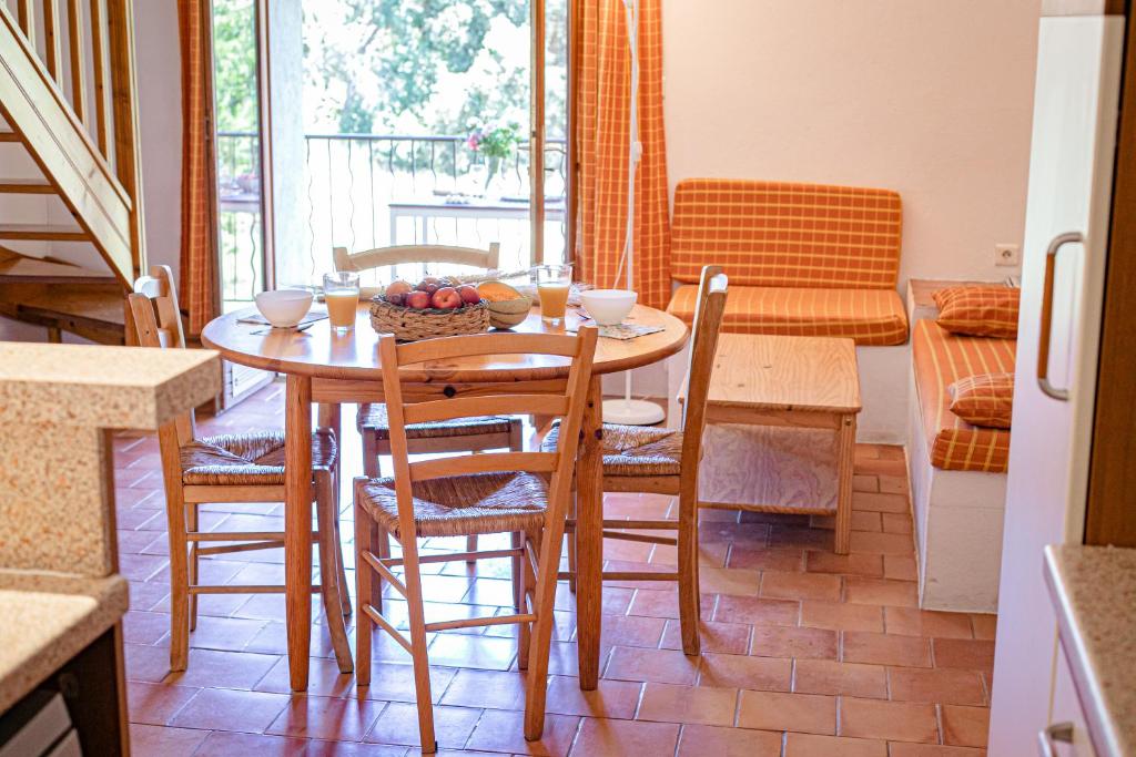 a dining room with a table and chairs with a bowl of fruit at Domaine De Sigalous in La Crau