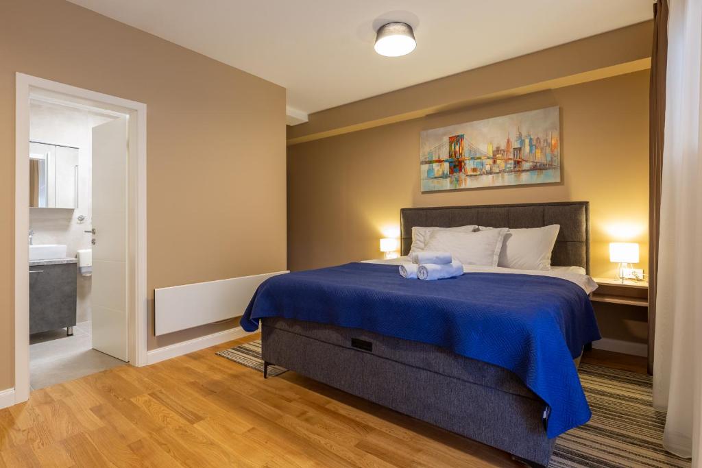 a bedroom with a bed with a blue blanket at Hotel Sky in Zadar