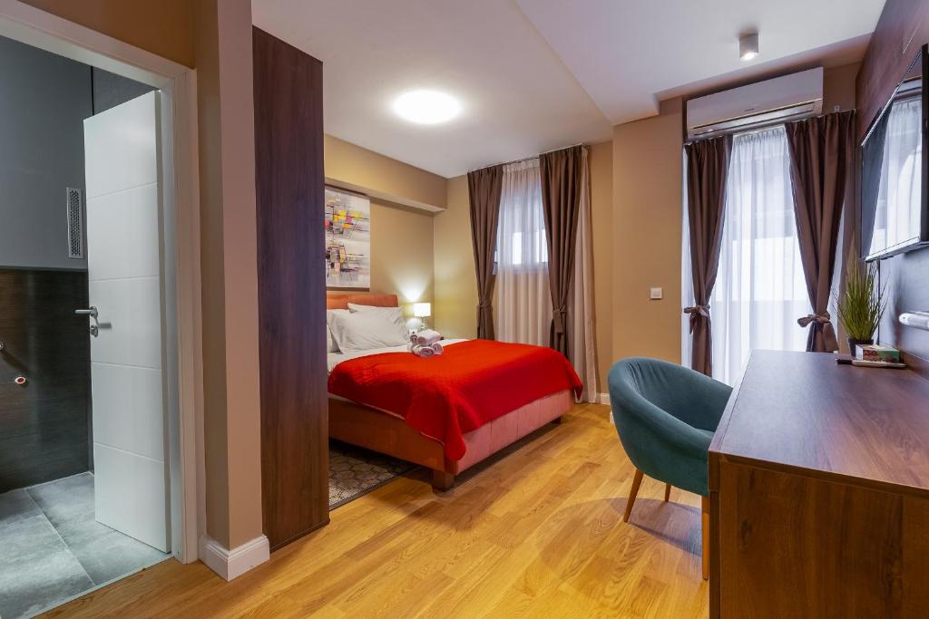 a bedroom with a bed with a red blanket at Hotel Sky in Zadar