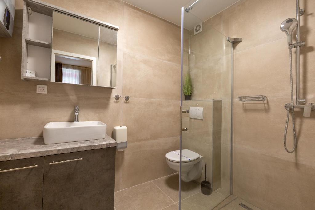 a bathroom with a shower and a toilet and a sink at Hotel Sky in Zadar
